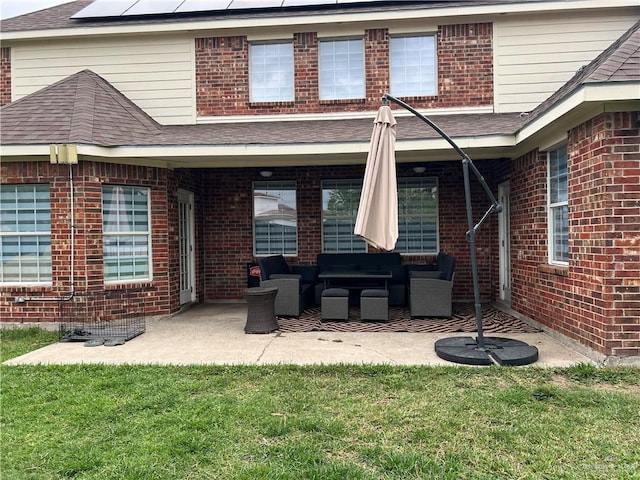 back of property featuring an outdoor hangout area, solar panels, a patio area, a lawn, and brick siding