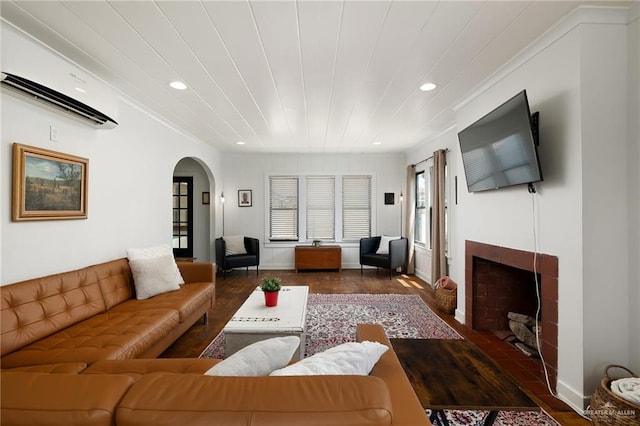 902 N 15th St, Mcallen, TX 78501 - living area with arched walkways, a wall mounted AC, recessed lighting, a tiled fireplace, and wood finished floors