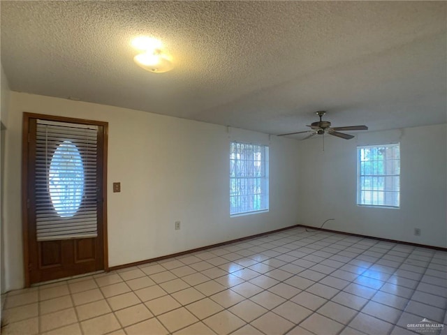 tiled spare room featuring ceiling fan and a textured ceiling