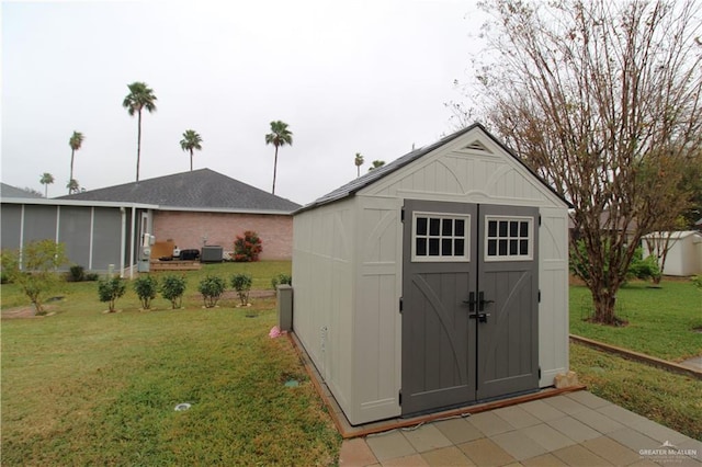 view of outbuilding featuring a yard and central air condition unit