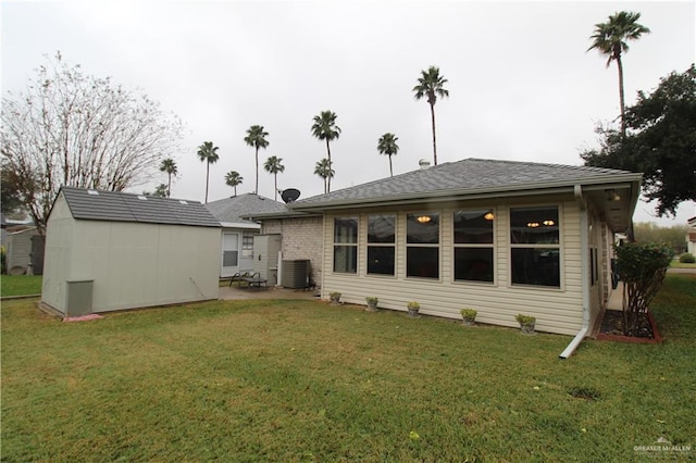 back of property with central air condition unit and a yard