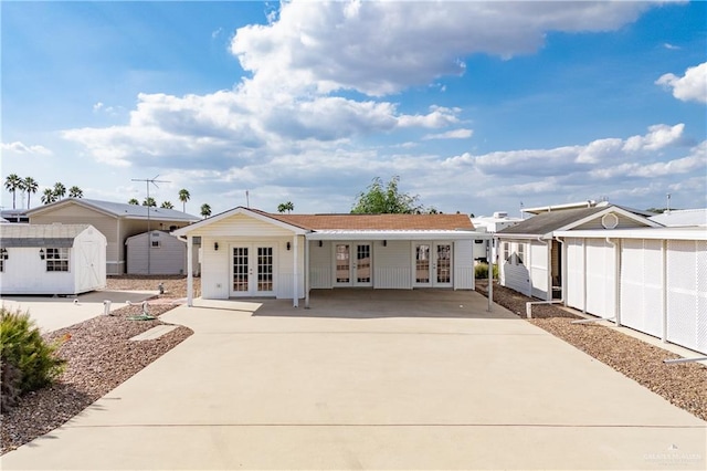 single story home with french doors and a storage unit