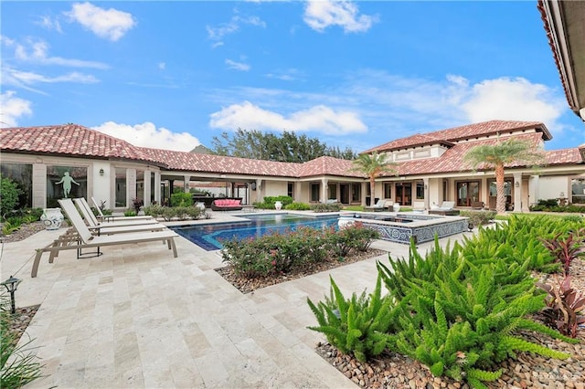 view of swimming pool featuring a patio area and an in ground hot tub