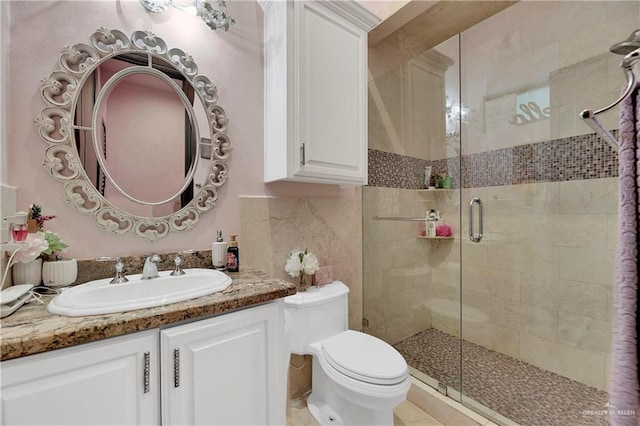 bathroom with vanity, toilet, and a shower with door