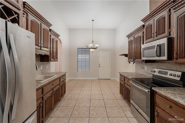 1711 Esperanza Ave, Hidalgo, TX 78557 - kitchen featuring stainless steel appliances, backsplash, a chandelier, light tile patterned floors, and hanging light fixtures