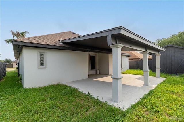 1711 Esperanza Ave, Hidalgo, TX 78557 - rear view of house featuring a patio, stucco siding, a shingled roof, and a storage unit