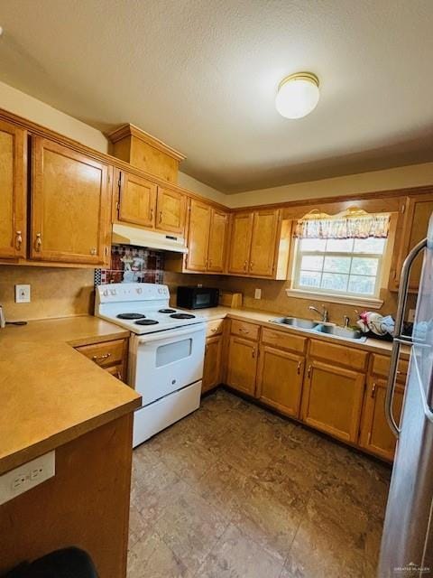 kitchen with white electric range oven, stainless steel refrigerator, and sink