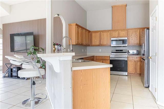 3004 San Federico Rd, Mission, TX 78572 - kitchen featuring a sink, light tile patterned flooring, light countertops, a peninsula, and appliances with stainless steel finishes