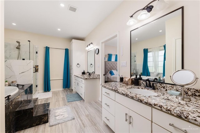 bathroom with shower with separate bathtub and vanity