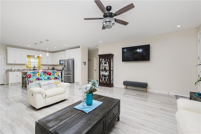 living room featuring ceiling fan and sink