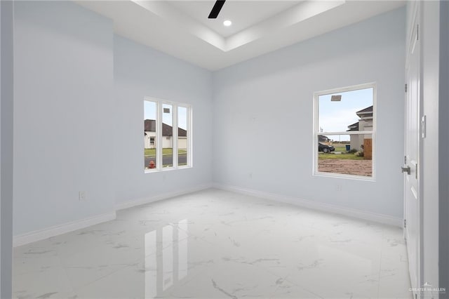 1232 Bridle Way, San Benito, TX 78586 - unfurnished room featuring light marble finish flooring, baseboards, a ceiling fan, recessed lighting, and a tray ceiling