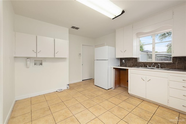 816 E 12th St, Mission, TX 78572 - kitchen featuring freestanding refrigerator, backsplash, and white cabinetry
