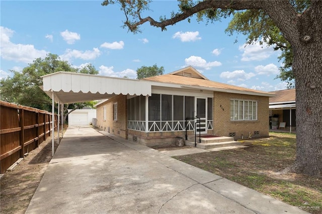816 E 12th St, Mission, TX 78572 - view of front of property with driveway, brick siding, an outbuilding, a sunroom, and a carport