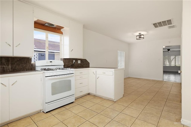 816 E 12th St, Mission, TX 78572 - kitchen featuring white gas range oven, a peninsula, tasteful backsplash, and healthy amount of natural light