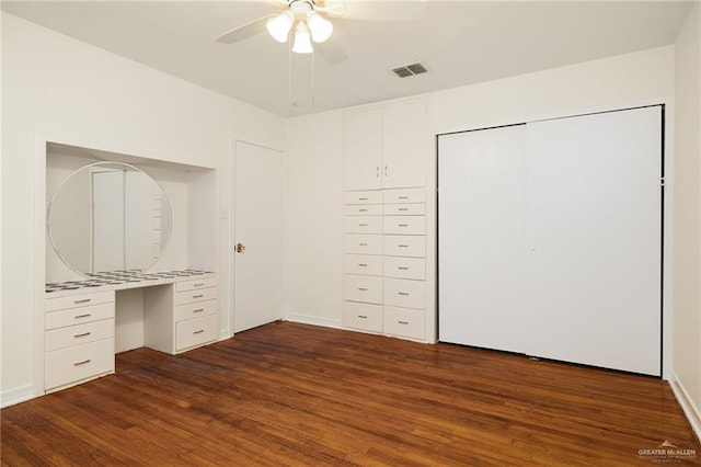 816 E 12th St, Mission, TX 78572 - unfurnished bedroom featuring dark wood-style flooring, built in study area, a ceiling fan, and a closet