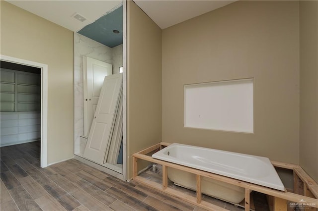 bathroom with hardwood / wood-style floors and a bathing tub