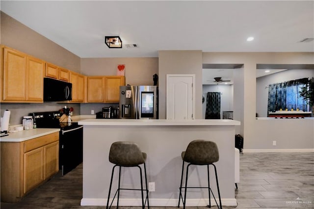 5302 Huisache Ave, Pharr, TX 78539 - kitchen with stainless steel refrigerator with ice dispenser, black microwave, electric range oven, a kitchen breakfast bar, and ceiling fan