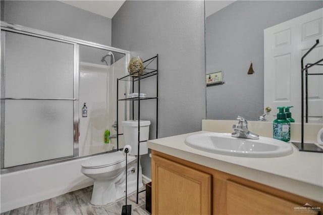 5302 Huisache Ave, Pharr, TX 78539 - bathroom with toilet, vanity, enclosed tub / shower combo, and wood finished floors