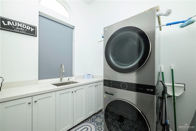 1102 Palm Blvd, Laguna Vista, TX 78578 - washroom featuring stacked washing machine and dryer, cabinet space, and dark tile patterned flooring