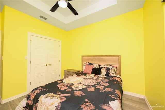 1102 Palm Blvd, Laguna Vista, TX 78578 - bedroom featuring a tray ceiling, wood finished floors, baseboards, and ceiling fan