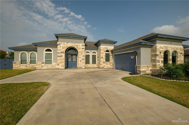 1102 Palm Blvd, Laguna Vista, TX 78578 - mediterranean / spanish house featuring stone siding, driveway, a garage, and a front lawn