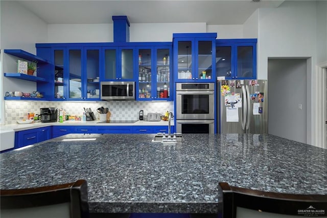 1102 Palm Blvd, Laguna Vista, TX 78578 - kitchen with appliances with stainless steel finishes, blue cabinets, backsplash, a sink, and dark stone countertops
