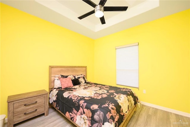 1102 Palm Blvd, Laguna Vista, TX 78578 - bedroom with a tray ceiling, wood finished floors, baseboards, and a ceiling fan
