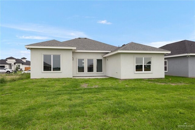 rear view of house featuring a yard