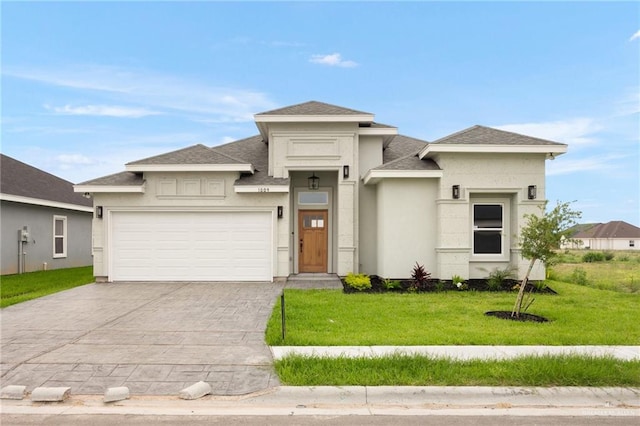 prairie-style home featuring a front lawn and a garage