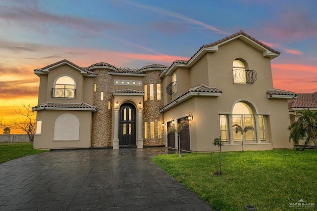 mediterranean / spanish-style home with a lawn and a garage