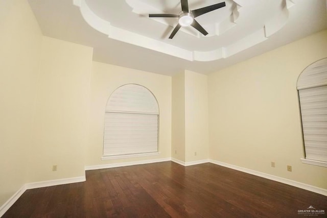 unfurnished room featuring hardwood / wood-style floors, ceiling fan, and a raised ceiling