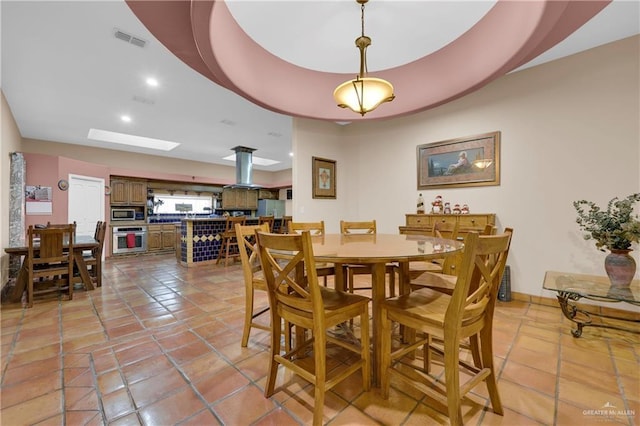 tiled dining room featuring a skylight