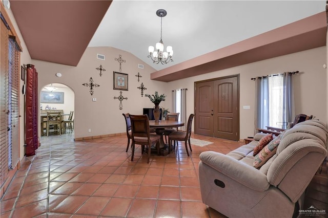 tiled dining room with lofted ceiling and an inviting chandelier