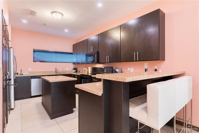 813 Travis St Unit 416, Mission, TX 78572 - kitchen with a sink, stainless steel appliances, a peninsula, visible vents, and a kitchen island