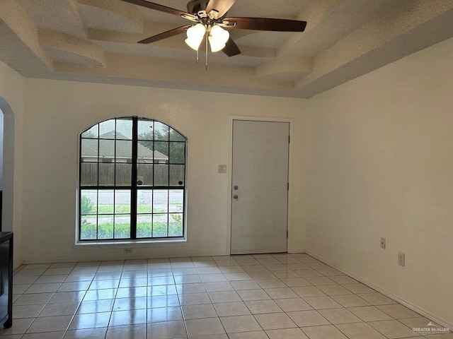 206 Justice Ln, San Juan, TX 78589 - empty room featuring light tile patterned flooring, arched walkways, a ceiling fan, coffered ceiling, and a raised ceiling
