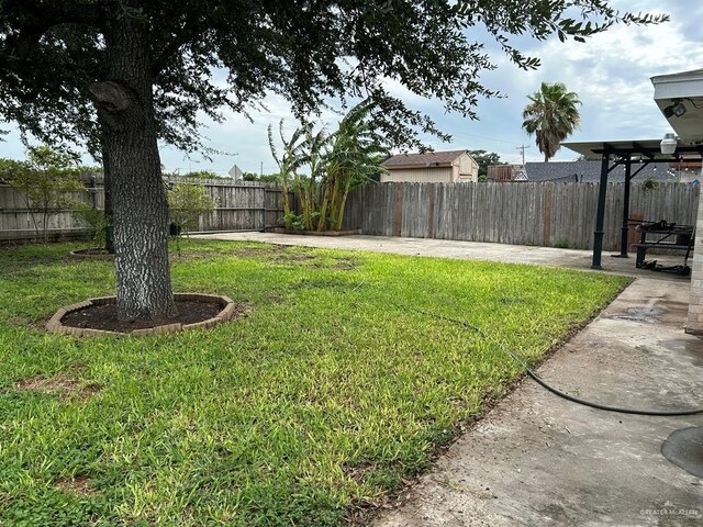 206 Justice Ln, San Juan, TX 78589 - fenced backyard with a patio area