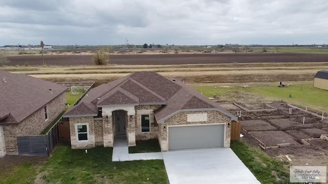 505 Independence Ave, San Benito, TX 78586 - view of front of house featuring fence, an attached garage, brick siding, concrete driveway, and a shingled roof