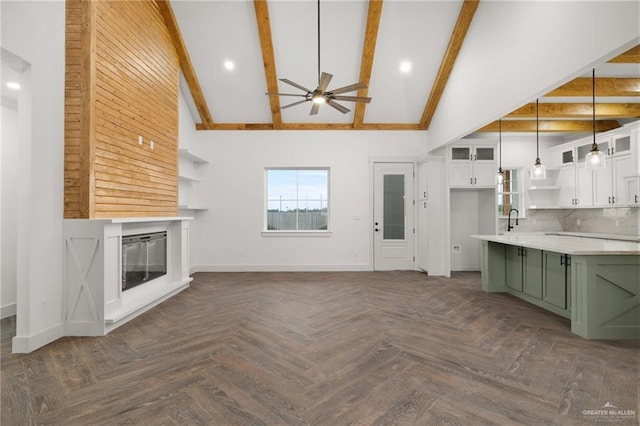 unfurnished living room featuring beam ceiling, ceiling fan, high vaulted ceiling, and dark parquet floors