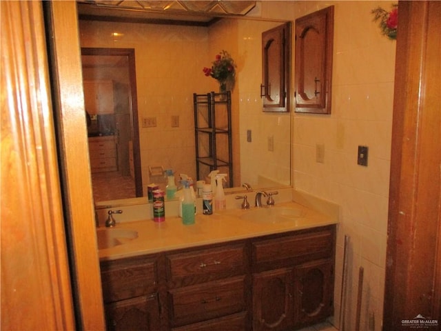 bathroom featuring vanity and tile walls