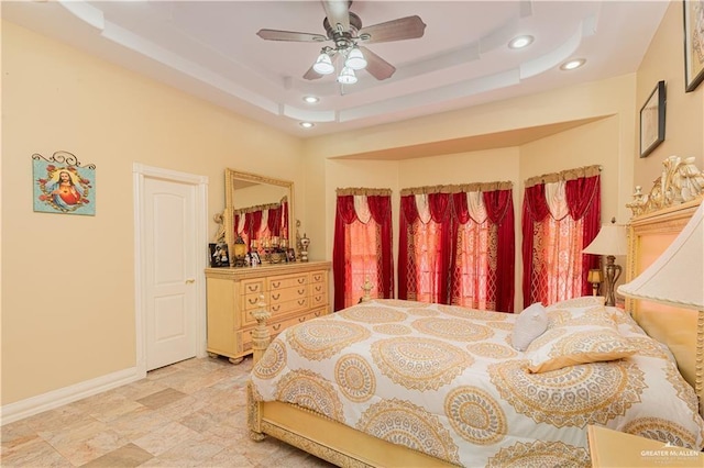 bedroom with a raised ceiling and ceiling fan