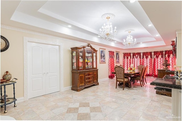 dining area with a raised ceiling and a notable chandelier