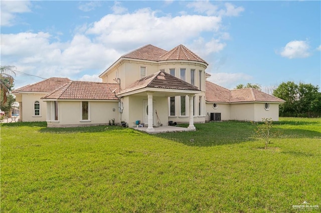 rear view of house featuring central air condition unit and a yard