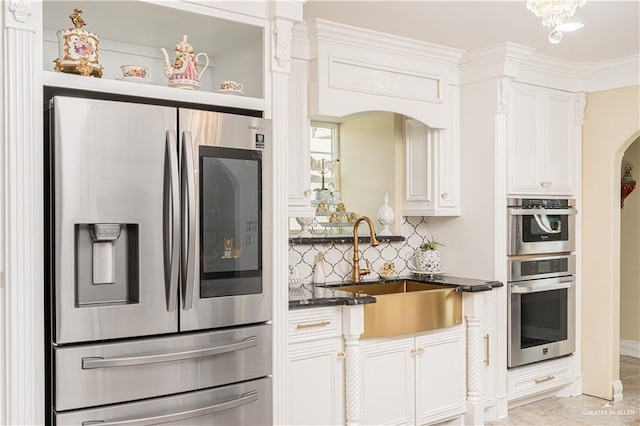 kitchen featuring tasteful backsplash, sink, white cabinets, and stainless steel appliances