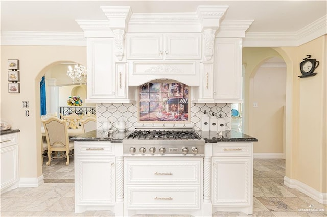 kitchen featuring decorative backsplash, dark stone counters, crown molding, white cabinetry, and stainless steel gas stovetop