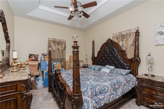 bedroom with a tray ceiling and ceiling fan