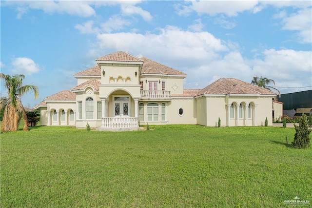 back of house with a balcony, a yard, and french doors