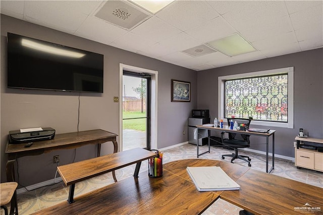 office space with a drop ceiling and a healthy amount of sunlight