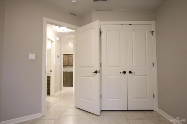 hall with light tile patterned floors