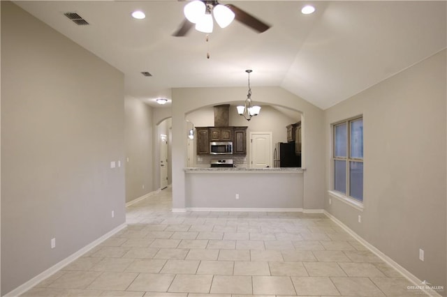 unfurnished living room with ceiling fan with notable chandelier, light tile patterned floors, and lofted ceiling