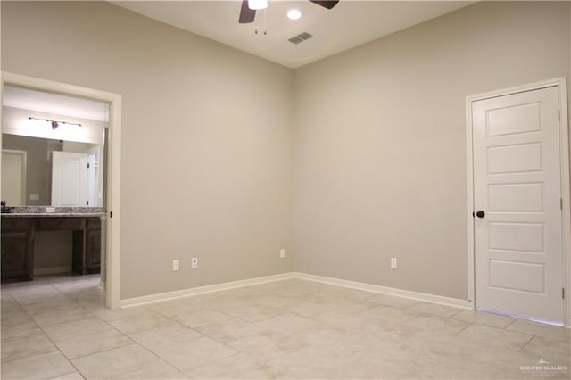 spare room with ceiling fan, light tile patterned floors, and vaulted ceiling